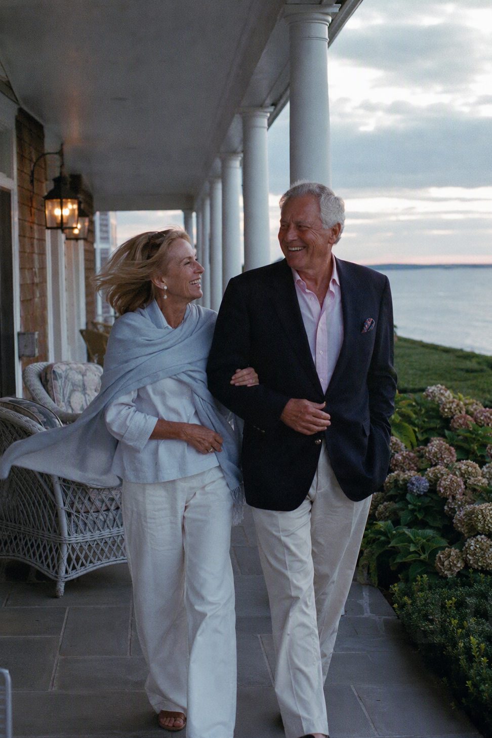 Couple on the veranda of their Hamptons estate at dusk